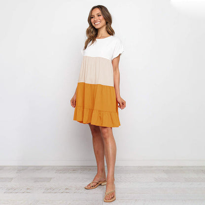 Jovita - Tinten van de zonsondergang: Speelse jurk met kleurblokken in wit, beige en goudoranje